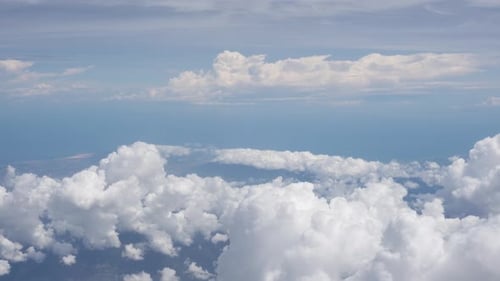 View of clouds in the blue sky from plane porthole