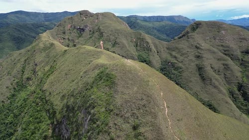 Aerial descends to lone hiker on summit ridge trail, Codo de los Andes