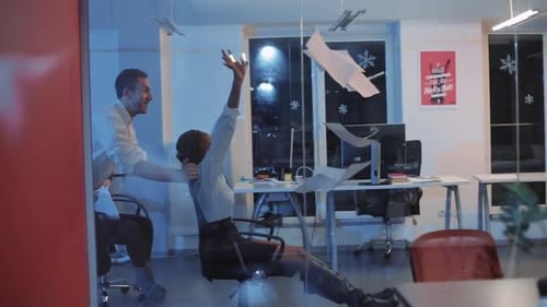 Colegas multiculturais andando em cadeiras para destilação em escritórios modernos, garotas espalhando papéis