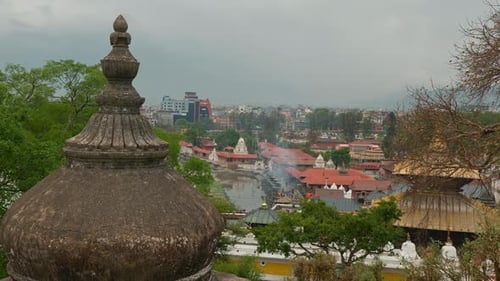 Cityscape view of Kathmandu, Nepal, with a cremation ritual in Pashupatinath Hindu Temple in the dis