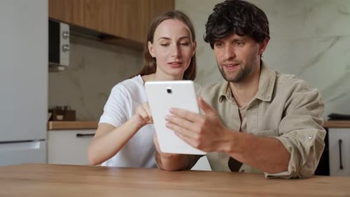 Married Couple is Shopping Online at Home on a Tablet