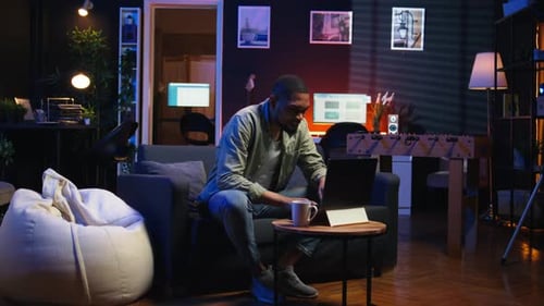 Young Adult Working at Home on Laptop at Night