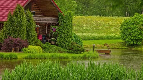Shot of a wooden cottage by the side of a lake throughout the day in timelapse. Beautiful green gras
