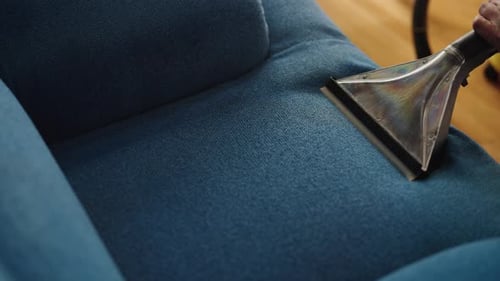 Vacuum Cleaner Head Cleans a Blue Couch