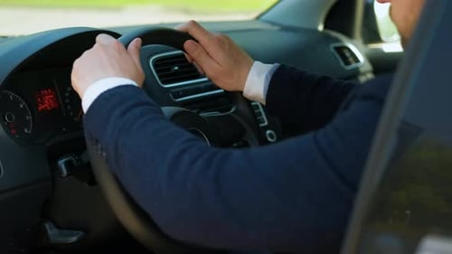 Man Driving Car in Urban Environment