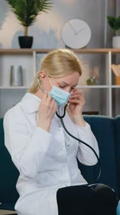 Goodlooking Calm Experienced Female Medical Worker Sitting on the Couch Together with Female Patient