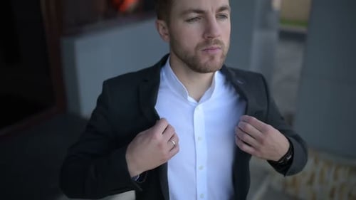 Man Fastening Jacket in Urban Setting