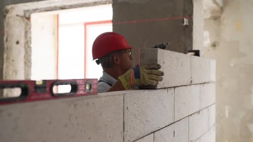 Bricklayer or Mason Lays Bricks to Construct Wall of Autoclaved Aerated Concrete Blocks Brickwork