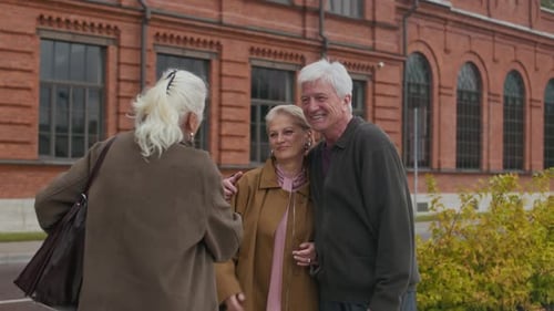 Senior Couple Greeting a Friend in the City
