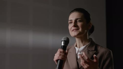 Woman Speaking Into Microphone at Corporate Event