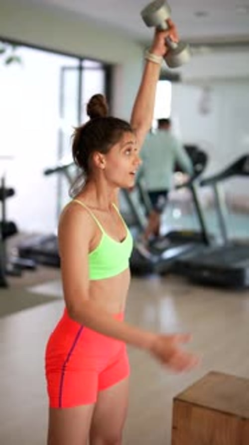 Woman Showing Determination and Strength While Performing Dumbbell Exercises at the Gym