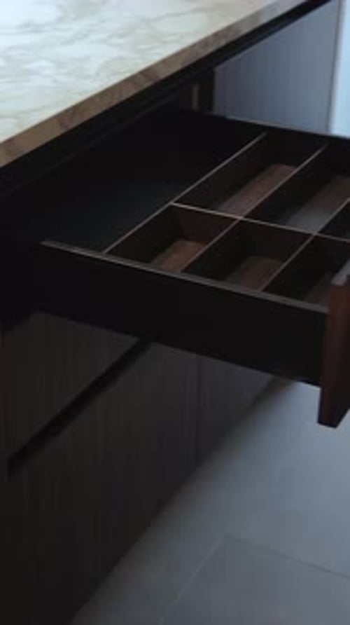 Closeup of a Woman's Hand Opening an Empty Kitchen Drawer Stylish Kitchen with Marble Countertops