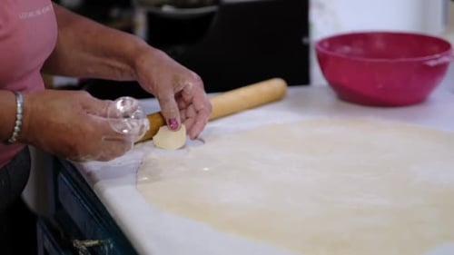 Woman Making Small Dough Shapes in the Kitchen
