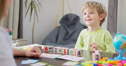 Child Learning Math with Colorful Blocks and Teacher