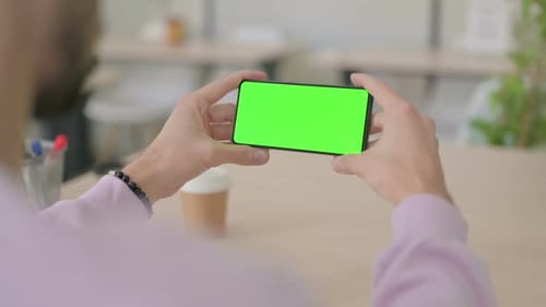 Rear View of Man Holding Smartphone with Green Chroma Screen