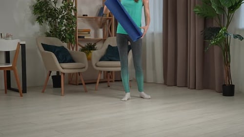 Woman Unrolls Yoga Mat in Living Room