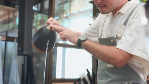 Asian attractive male barista or waiter working in coffeehouse shop.