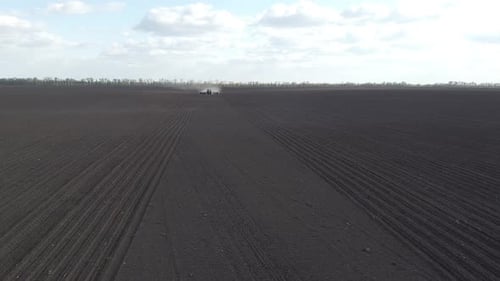 Tractor with yellow seeder working on the field in Ukraine OA Lexa