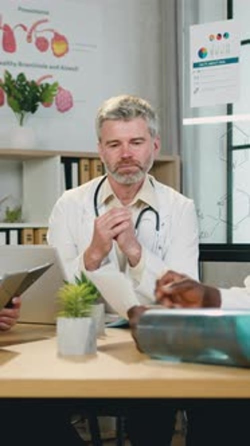 Doctors Discussing Medical Charts in Office Setting