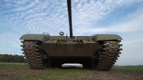 Static Tank on Grassy Field under Cloudy Sky