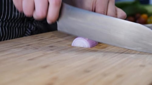 woman cutting onions on the wooden table