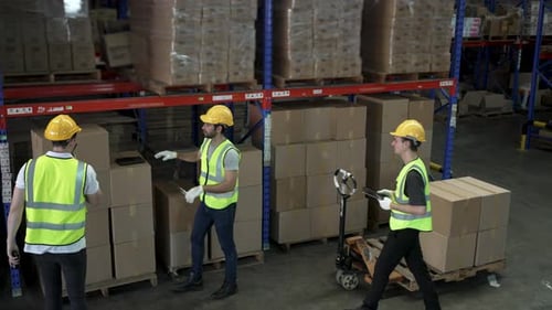 Blue collar workers are working at warehouse.