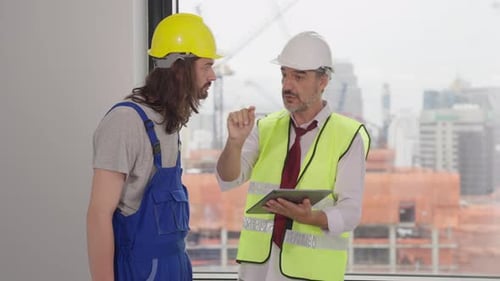 Engenheiros usando o plano de projeto, discutindo e trabalhando