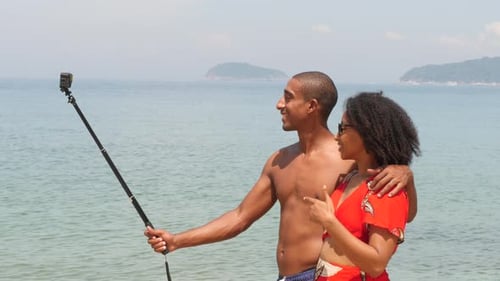 Haitian Couple Filming a Video at the Beach on Summer in Tropical Island