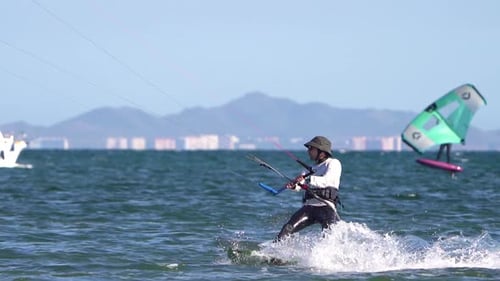 Sportsman practicing kite surf sport at the beach on a windy day at the Spanish coasts