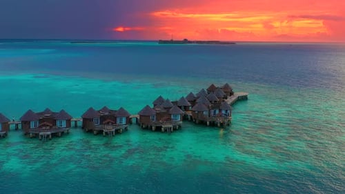 Overwater Villas at the Time Amazing Sunset in Tropical Sea with Coral Reef