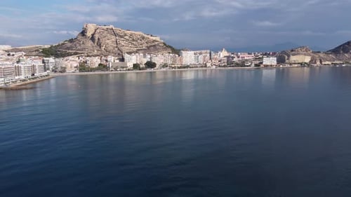 Aerial reveal of the seafront, castle and city of Alicante, Spain