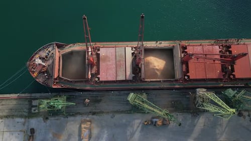 Aerial View of Big Cargo Ship Bulk Carrier is Loaded with Grain of Wheat in Port at Sunset