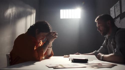 Intense Interrogation: Prisoner and Detective in Jail Cell