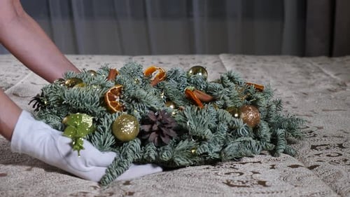 Gloved Hands Arranging Decorative Christmas Centerpiece Indoors