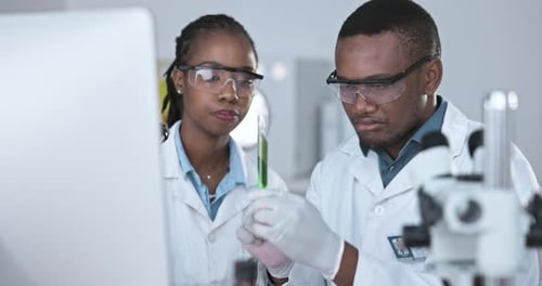Scientists Examining Green Liquid in Test Tube