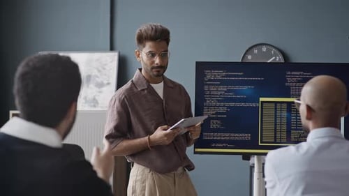 Indischer Entwickler präsentiert Code vor Kollegen im IT-Büro
