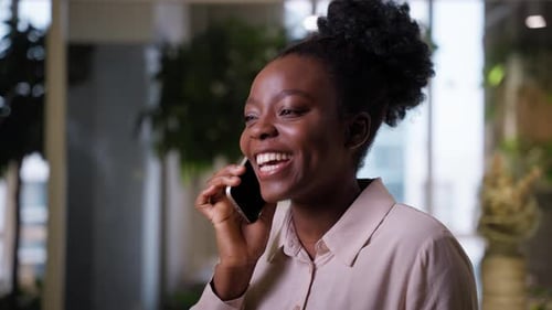 Businesswoman Talking Mobile Phone in Office Happy Positive African American Ethnic Cheerful