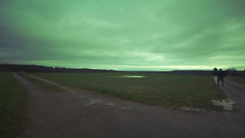 Moderner schwarzer Schwertkämpfer wartet auf offenem Feld unter grünem Himmel auf Kampfgegner, Europa, 4K Mu