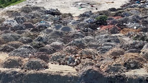 Aerial dump site with rubble, soil mounds and construction waste