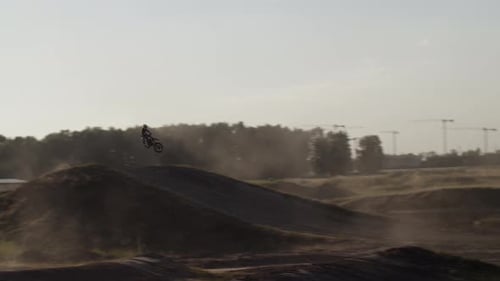 Motocross Rider Performing Jumps on Dirt Track