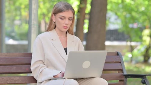 Woman Working on Laptop on Park Bench
