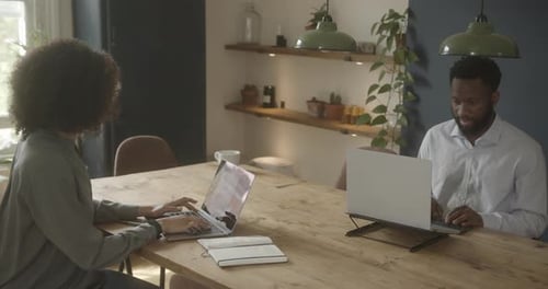 Couple Working on Laptops at Home Office