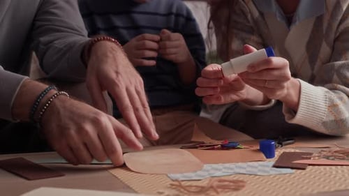 Boy and Parents Using Glue and Paper when Crafting at Table