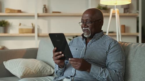 Senior man using tablet in living room