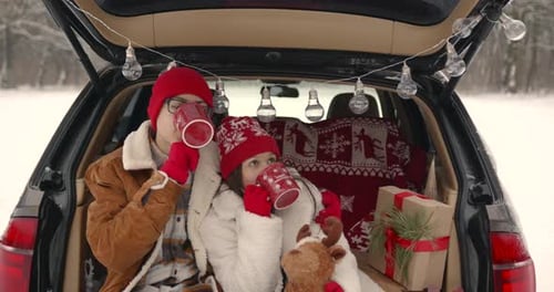 Family Sitting in a Car Among Winter Forest