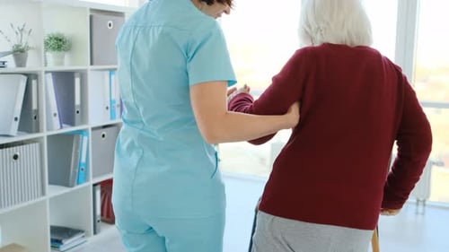 Caregiver Helping Elderly Woman to Walk