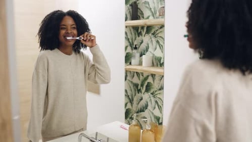 Young Woman Brushing Teeth in Modern Bathroom