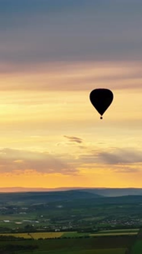 Aerial drone view of a hot air balloon flying above Chisinau, Moldova at sunset. Vertical