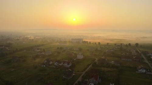 Aerial View Foggy Sunrise Over Residential Houses in Suburban Rural Area