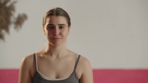 Front View of Pretty Young Woman Looking at Camera with Tired Smile Indoor Footage of a Girl in